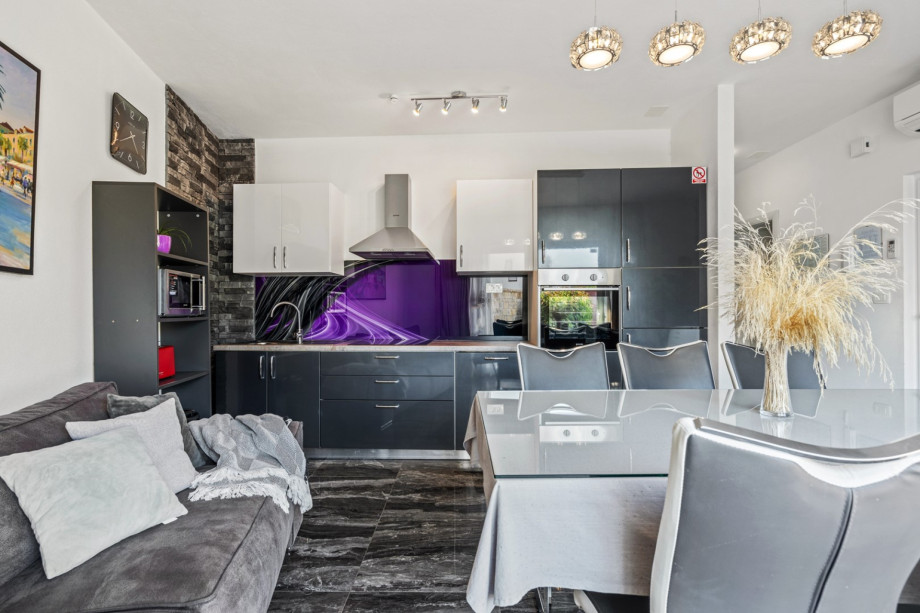 a living and dining area with fully equipped kitchen and exit toward pool area, A/C, TV