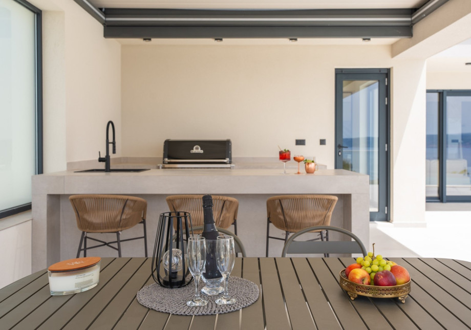 Covered dining area that can seat eight people comfortably and a kitchenette