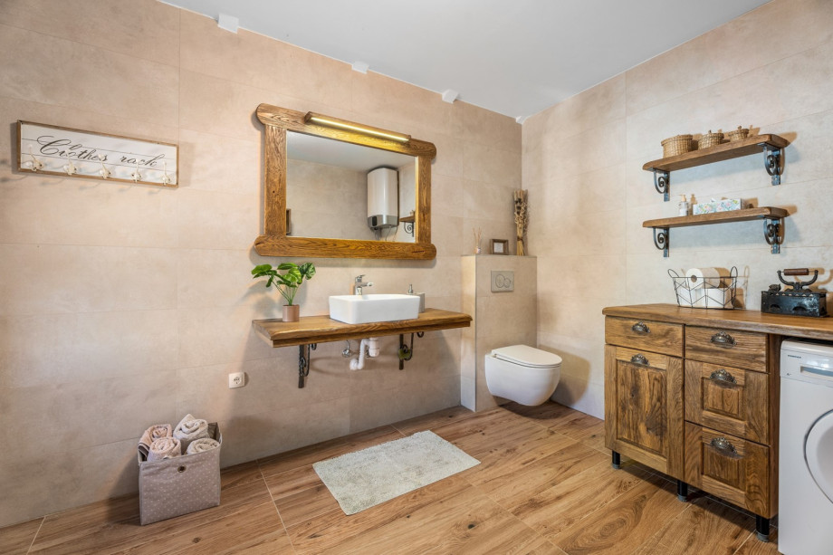 A separate family bathroom with a shower and a washing machine. There is also an iron with ironing amenities.