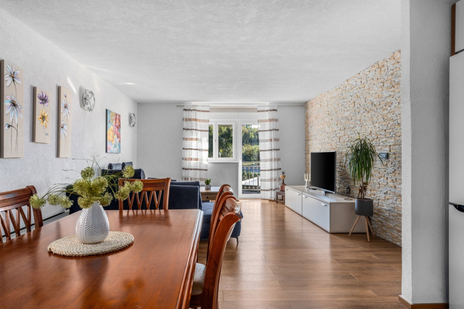 Dining table, living room with very comfortable sofa, a TV and a balcony with pool views