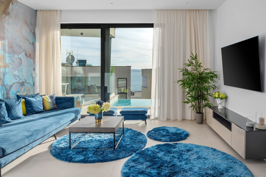 Another living area with a sofa and a TV with a PlayStation5, next to it is a separate toilet