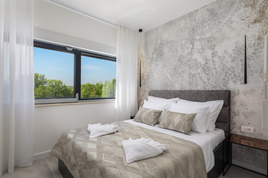 Bedroom No2 (10.5sqm) with a queen size bed 160cm x 200cm, A/C, TV, and a family bathroom (3.7sqm) with a shower next door