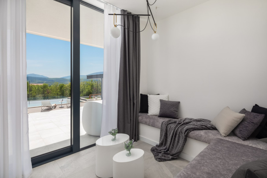 A small living area open concept with a TV and sofas and a direct approach to the sun deck area