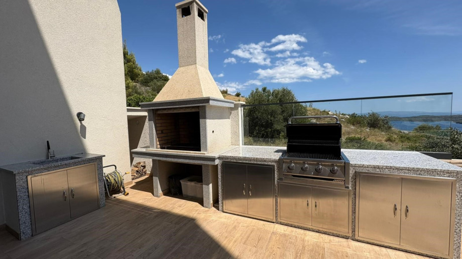A spacious outdoor dining area with a barbecue (woods/charcoal), and gas barbecue.