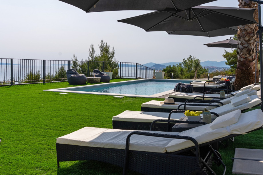 Surrounded by eight sun loungers, umbrellas, and a sea-facing terrace covered with artificial grass for added comfort