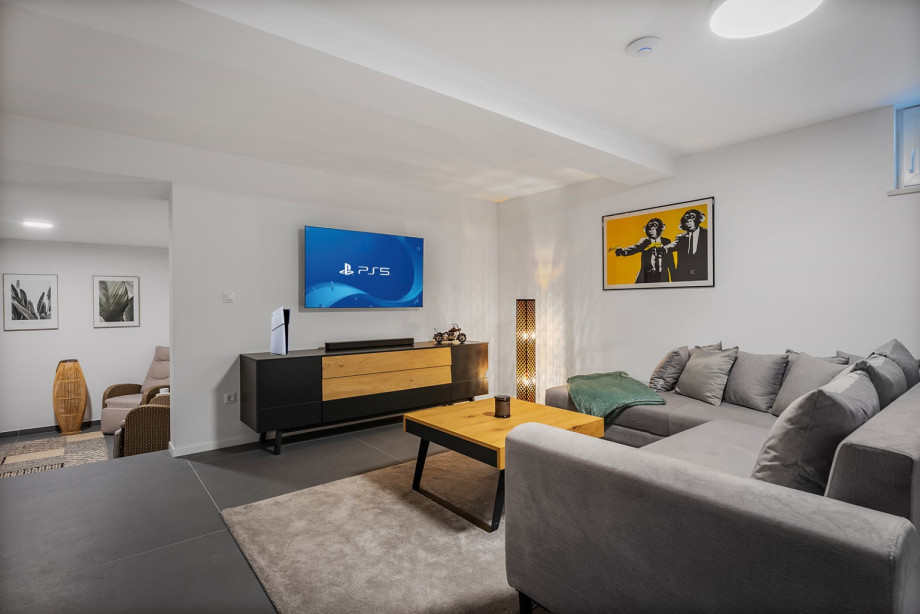 Media room with a sofa, PlayStation5, a TV and some games for more fun