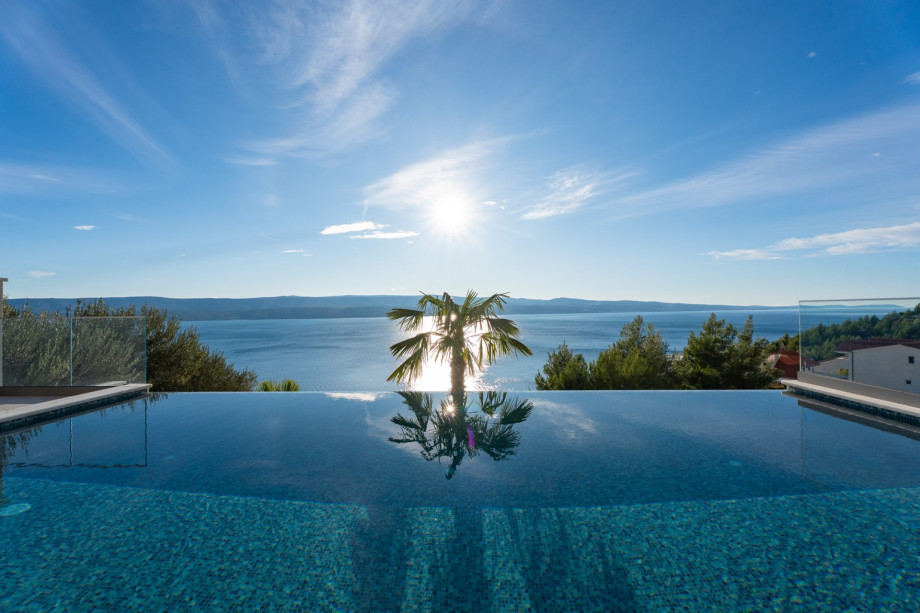 The heated infinity pool offers a stunning sun-drenched reflection and spectacular sea views.