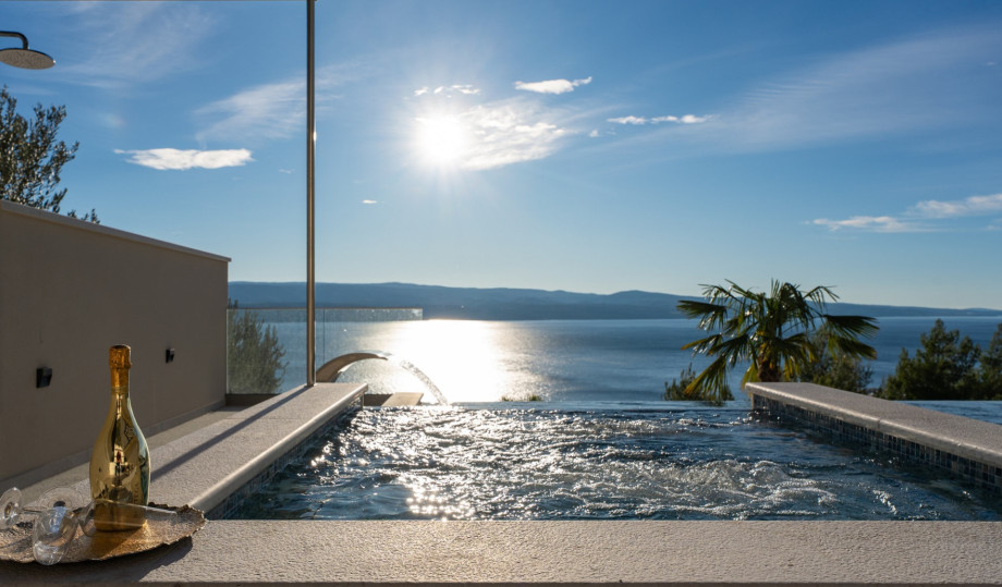The private, heated infinity pool features an attached hydromassage area, perfect for enjoying the incredible views.