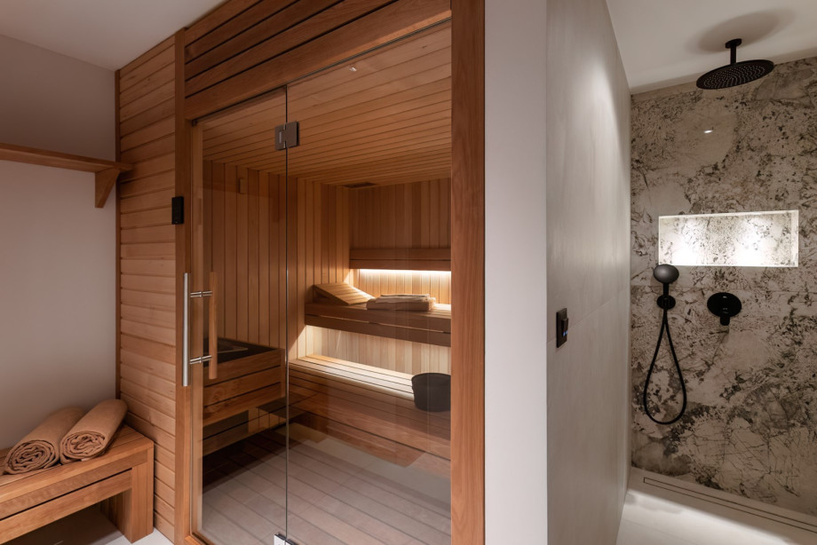 Wellness amenities in the spa zone include a Finnish sauna with a sleek walk-in shower and a separate toilet.