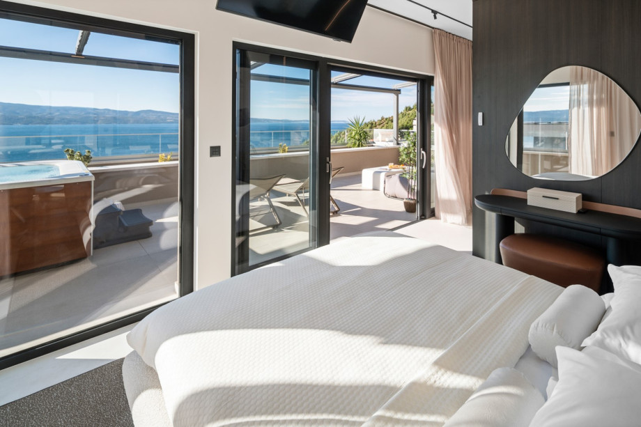 This comfortable bedroom opens via glass sliding doors onto the private terrace, which features the hot tub (whirlpool).