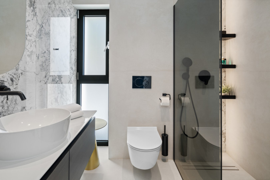 This luxurious en-suite bathroom features a toilet, a vanity with a sink, and a walk-in shower.