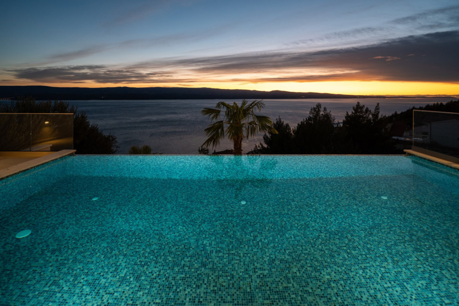The private, heated infinity pool features a healthy electrolysed filtration system and offers breathtaking sea views, as seen dramatically at sunset.