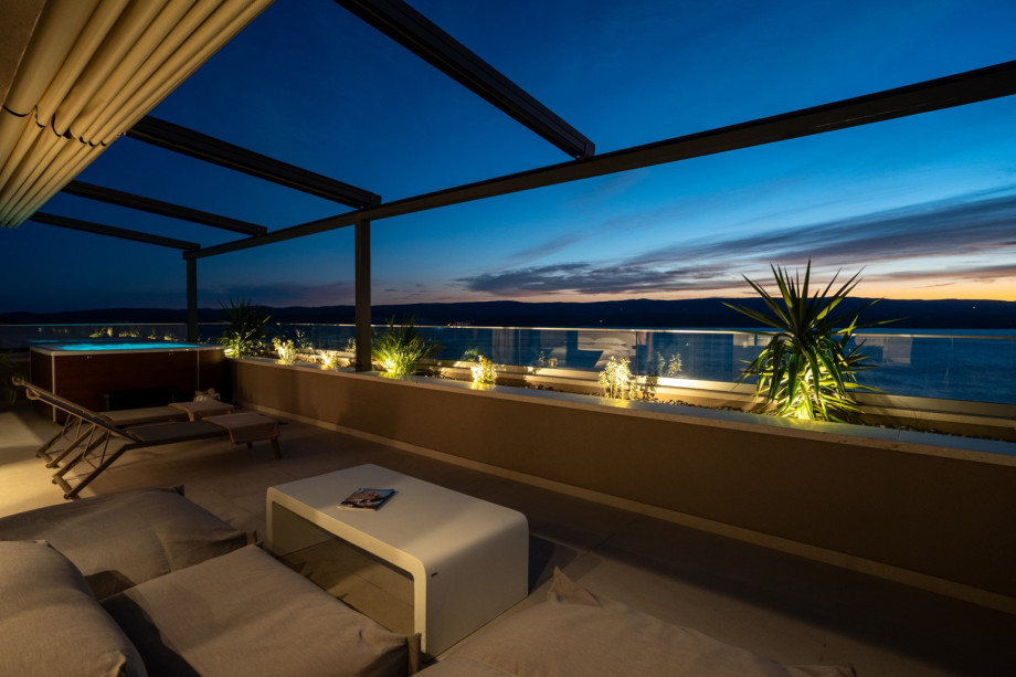 The upper terrace lounge corner with two deck chairs and lighting, located on the top level outside the master bedroom, with amazing views