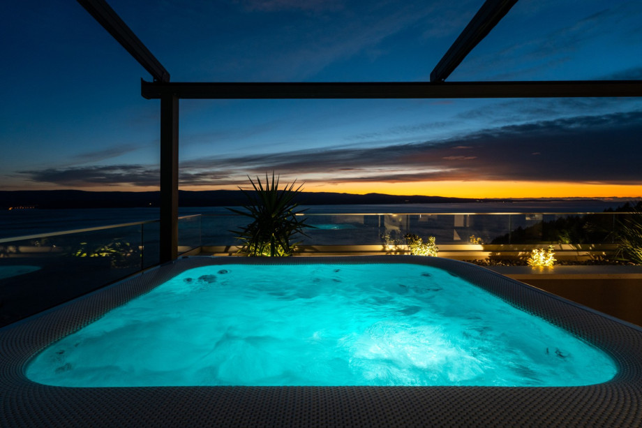 This image focuses on the Jacuzzi (Whirlpool) on the upper terrace, which offers a perfect view of the sea and sunset.