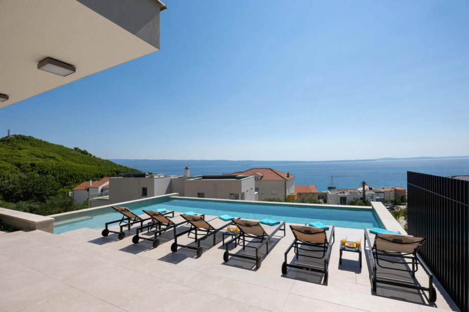 The stunning sun deck offers a private pool, sun loungers, and spectacular, panoramic views of the sea.