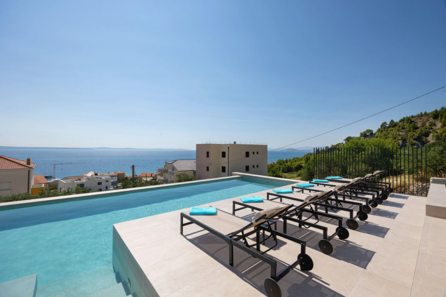 Sun deck with 6 deck chairs beside the 11.4m x 4.5m private heated pool, perfect for soaking up the sun.