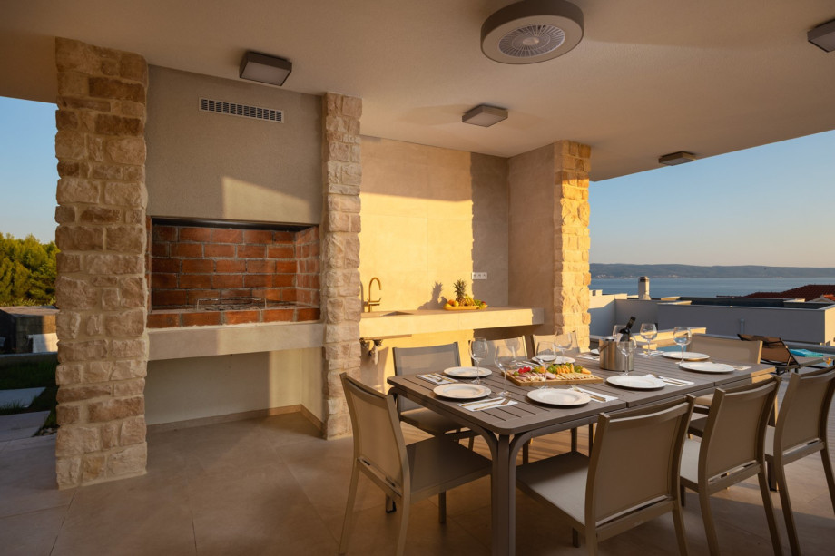 Covered alfresco dining area with a built-in barbecue, ready for family or group meals for up to 8 people.