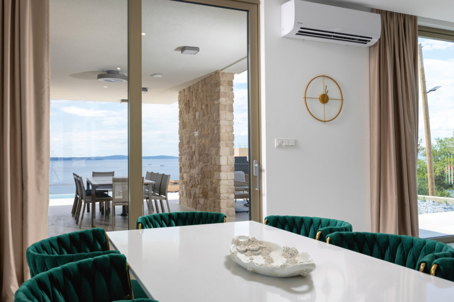 The elegant dining area is situated near the sliding doors that offer magnificent sea and neighborhood views.