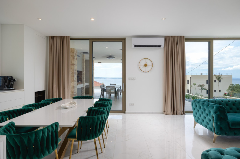 The fully air-conditioned living space includes the dining area and sliding doors that open to the outdoor patio.