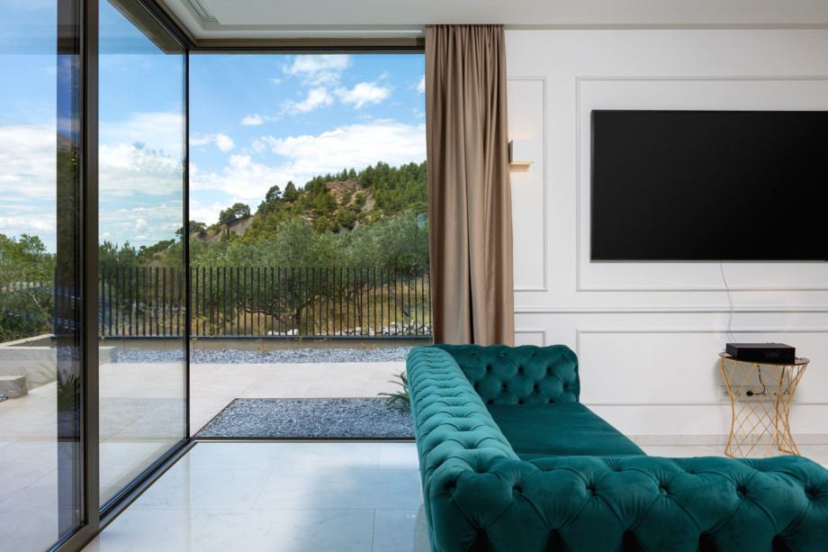 The fully air-conditioned living room's sliding doors offer access to the fenced property.