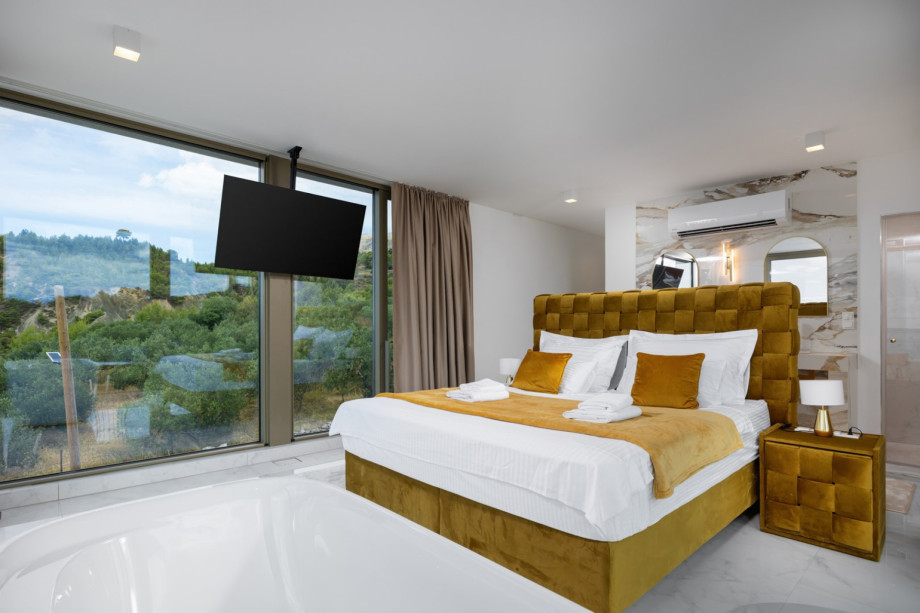 Fully air-conditioned Bedroom 1 with a King-size bed and access to an en-suite bathroom.