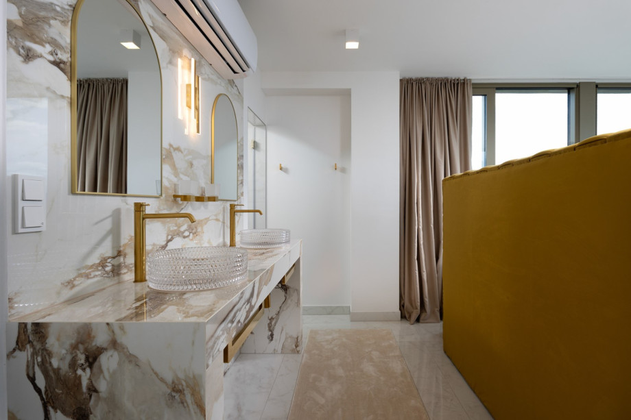 The South-facing Bedroom 1 includes an en-suite bathroom with double basins and luxurious fixtures.