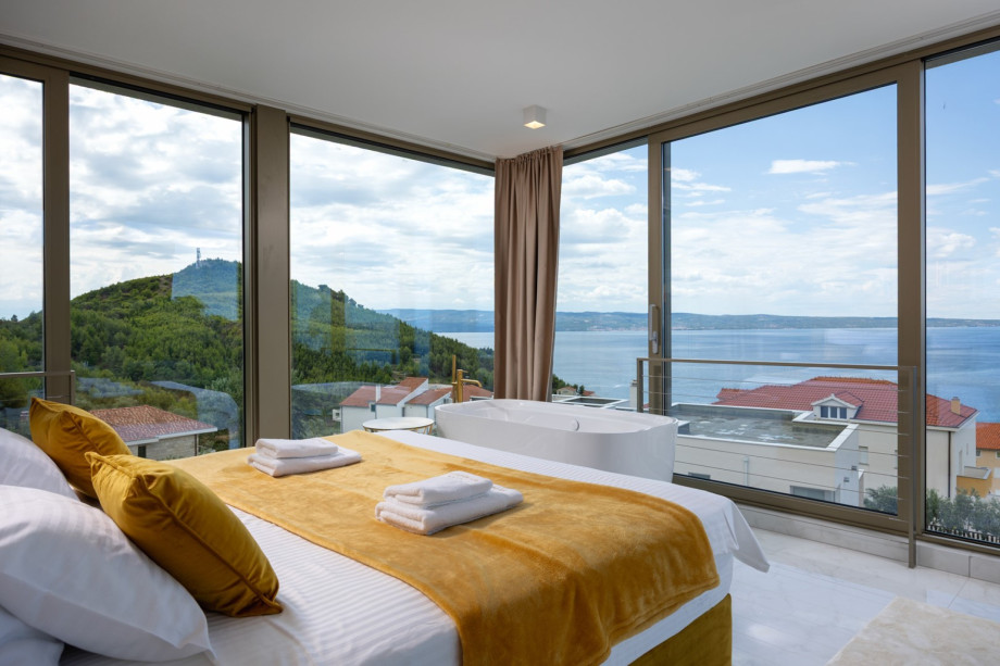 South-facing Bedroom 1 (30 sqm) featuring a King-size bed and a luxurious freestanding bathtub.