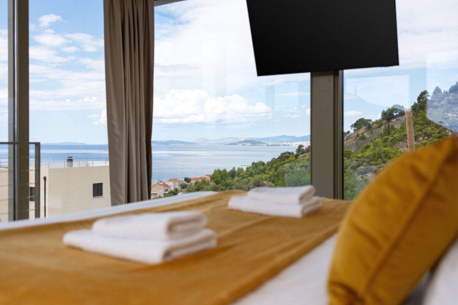 Upper-level King-size bed (180cm x 200cm) with sea views and a wall-mounted flat-screen TV.