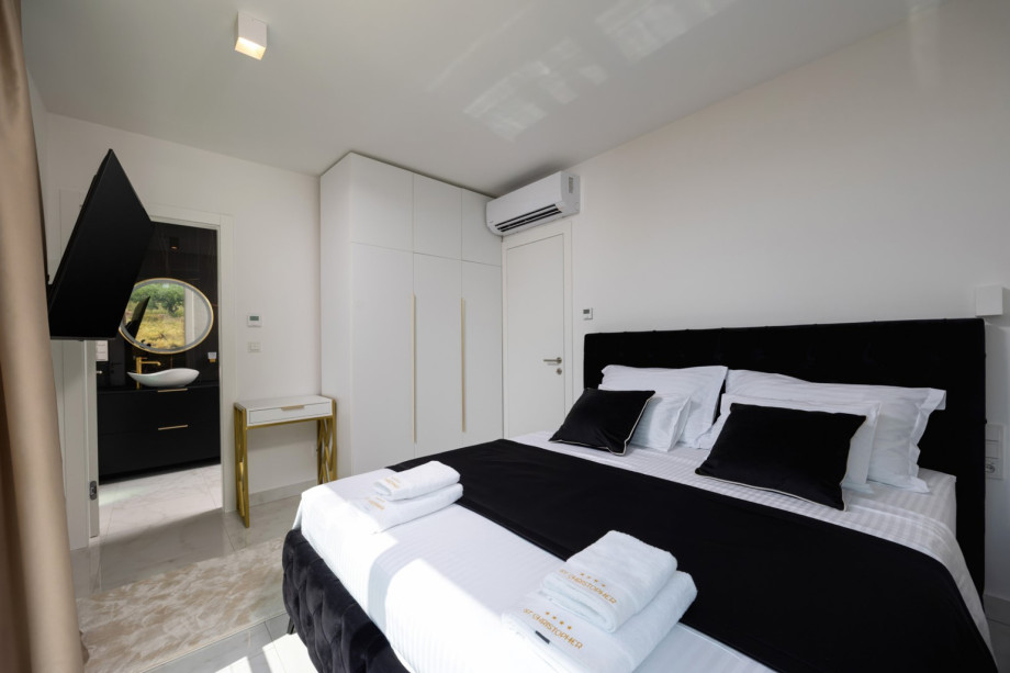 Bedroom 2 (13 sqm, East-facing) features a King-size bed, a wardrobe, and an en-suite bathroom.