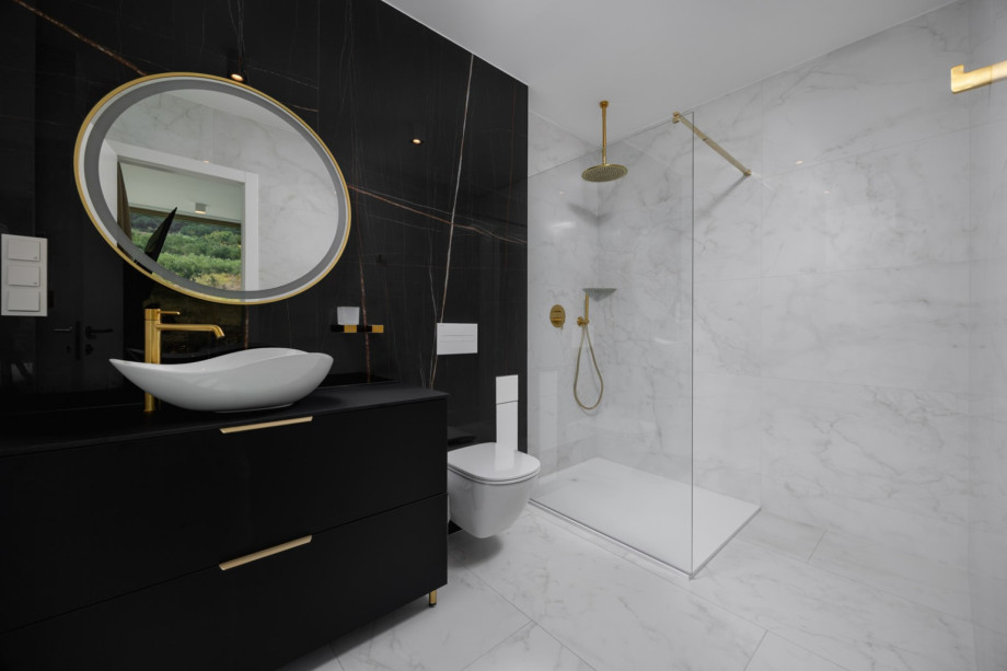 En-suite bathroom with a shower for one of the four elegant bedrooms, offering modern black and white marble.