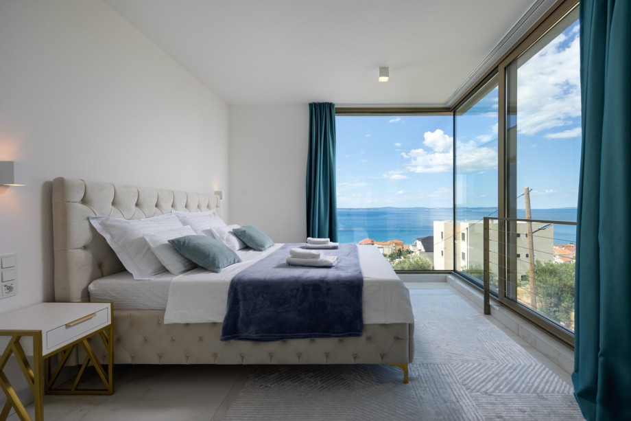 Bedroom 3 (17 sqm, South-West facing) with a King-size bed and a sliding door for sea views.