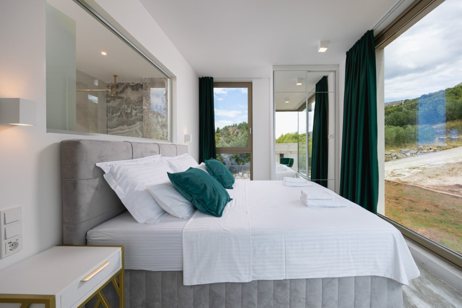 Bedroom 4 (16 sqm, North-facing) offers amazing views of olive groves and mountains, with an en-suite bathroom.
