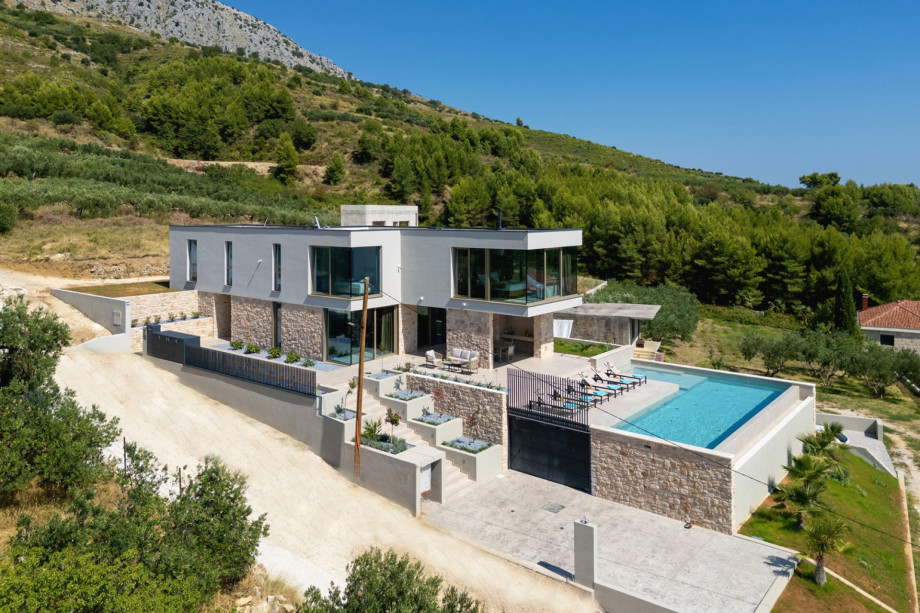 Aerial view of the 203 sqm villa with its private pool, fenced property, and surrounding natural environment.