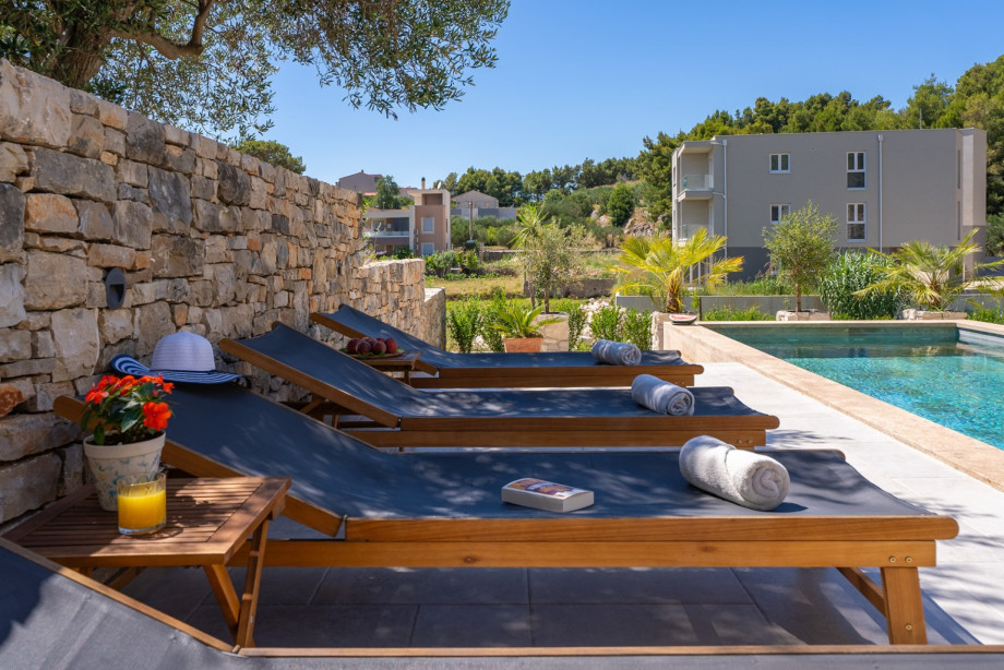 There is a sun deck area with 6 deck chairs, an outdoor shower, a covered outdoor dining area