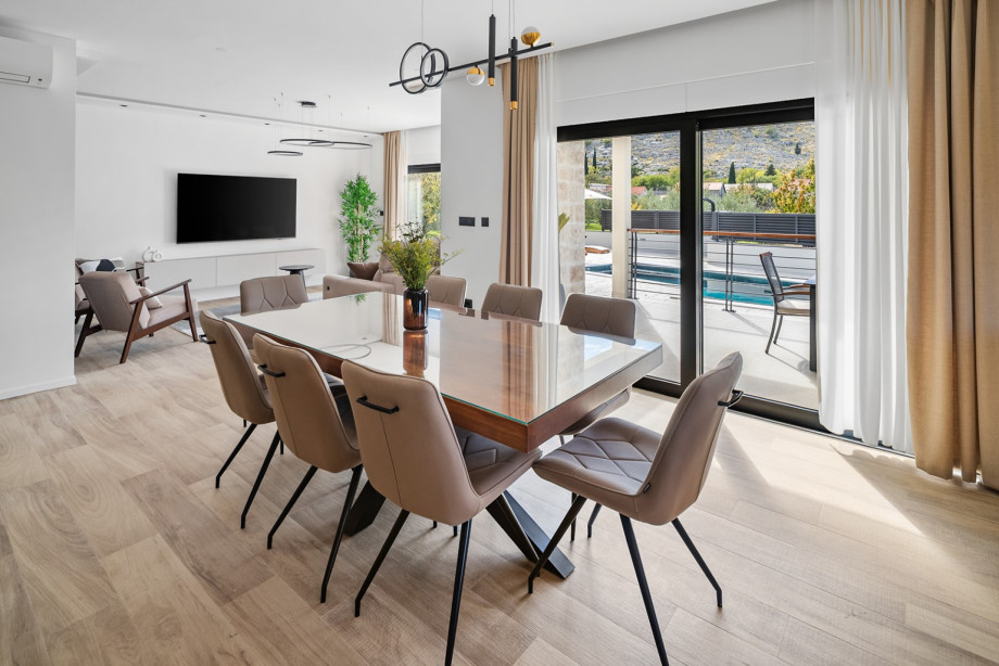 Enjoy shared family breakfasts at this grand wooden dining table with direct access to the outdoor terrace.