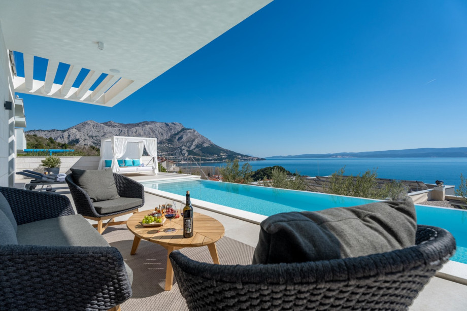 The outdoor sitting area is next to the pool, with an amazing sea view.