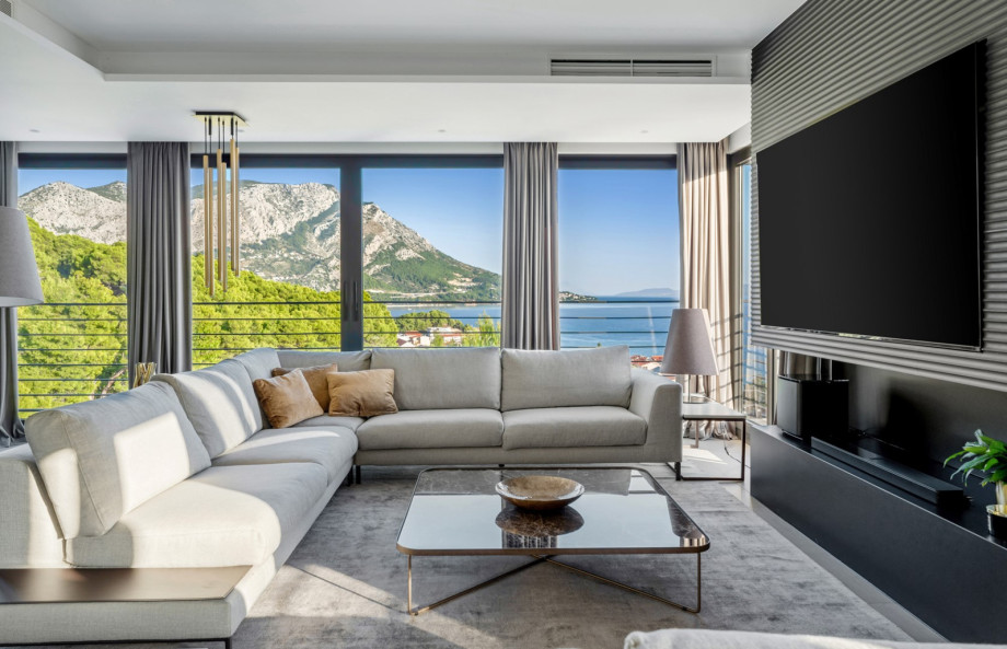 An Electric Steam Fireplace, a few sofa areas, and spectacular sea views and mountain views wherever you look