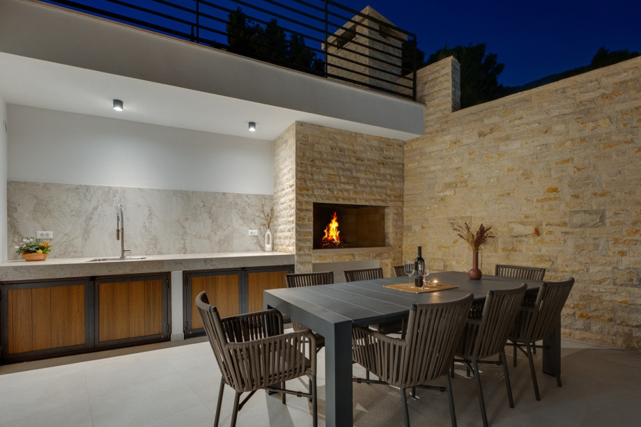 The outdoor dining area with the barbecue overlooking the mountains and the sea