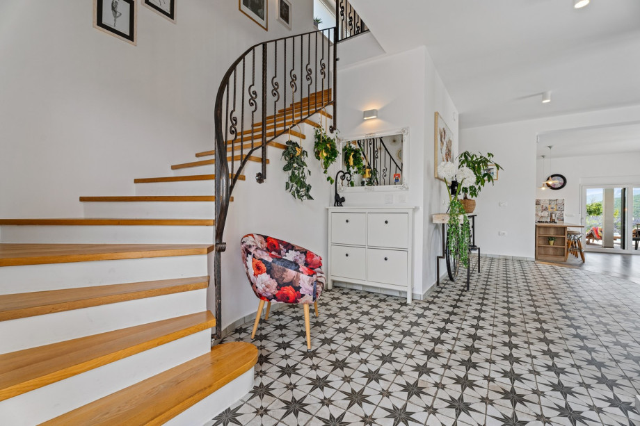 The stairs are curved gracefully to the first floor, inviting visitors to explore and admire.