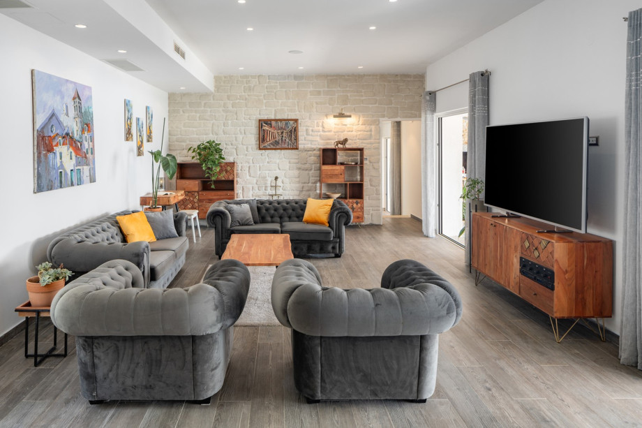 Living room with sofas,a reading/working corning, a flat screen TV, and doors toward the outdoors