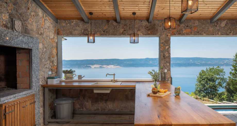 Kitchen island with stools overlooking the pool, the natural surroundings, island Brac and the sea