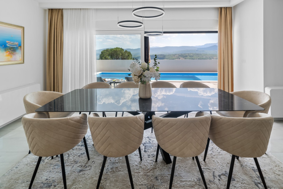 A comfortable dining table perfect for enjoying homemade meals together overlooking the pool and sundeck