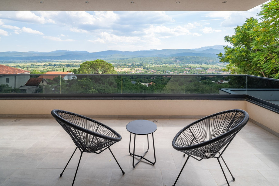 Bedroom No. 2 offers access to a terrace with a table for two and a beautiful view of the landscape.