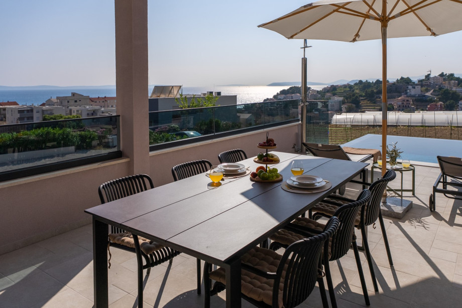 Covered dining terrace with seating for 8 and wood/charcoal BBQ