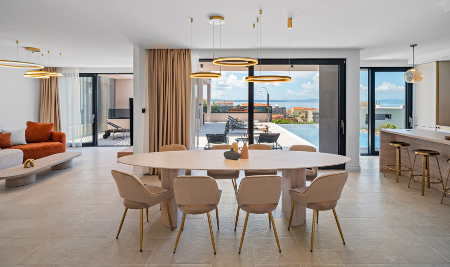 Large glass walls connect the villa's interior with the exterior, boasting a modern swimming pool area