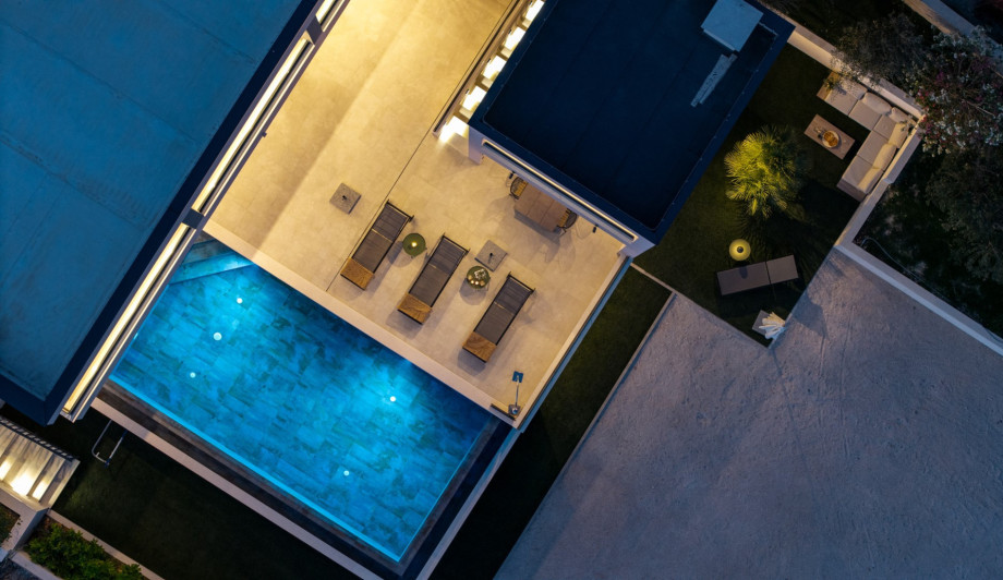 The villa offers seamless indoor-outdoor living with a sauna, lounge chairs, and inviting spaces perfect for relaxing and memorable gatherings