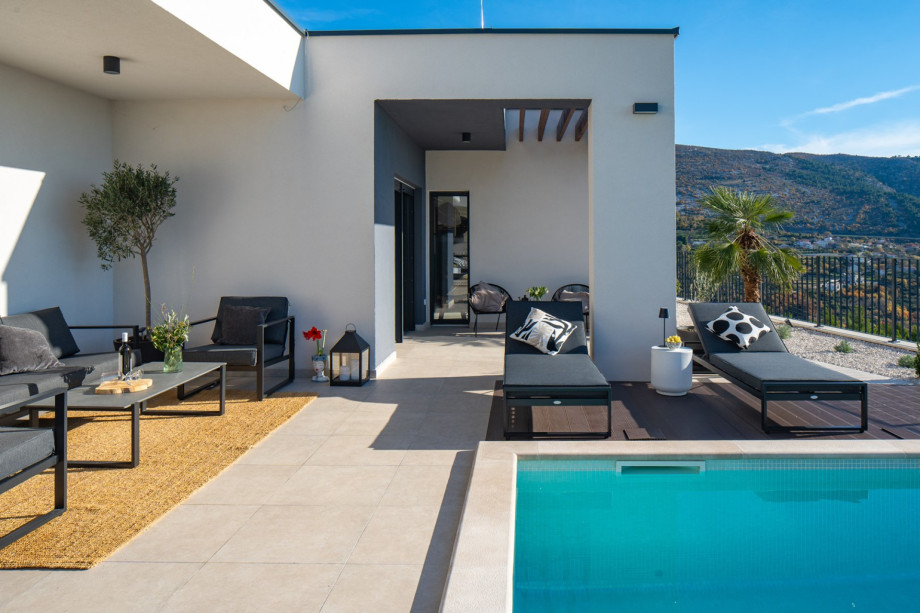 Exterior showcasing the comfortable lounge corner and pool access, ideal for serene escapes.