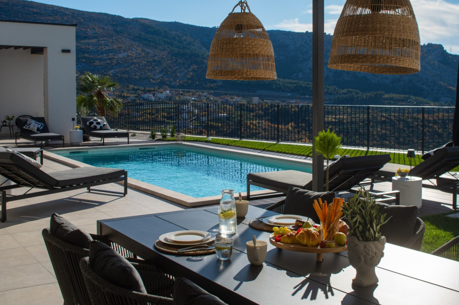 View of the 8m x 4m pool from the shaded outdoor dining area, featuring overhead lighting.