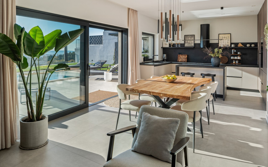 The open-plan design connecting the fully equipped kitchen and the dining area to the pool terrace.
