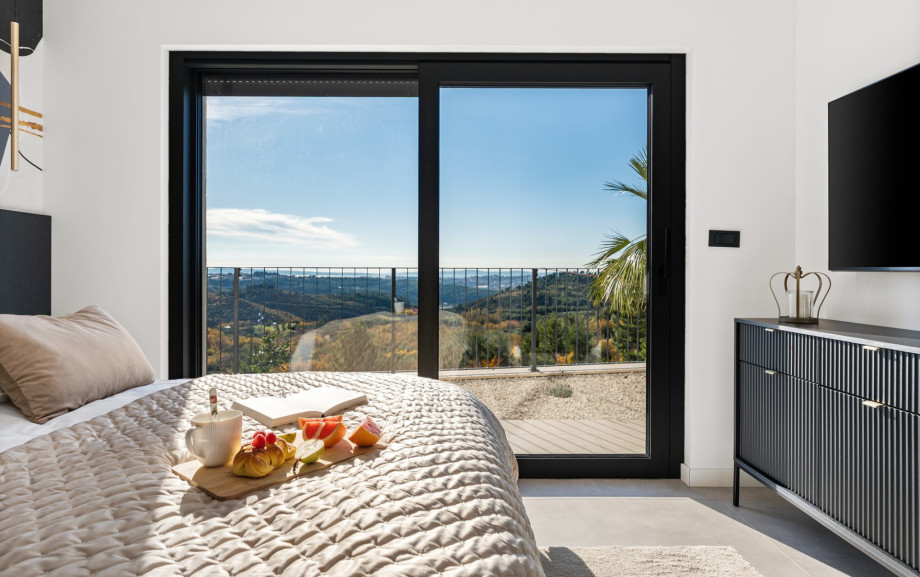 Master Bedroom, featuring a king-size bed and TV, with direct access to the outdoors.